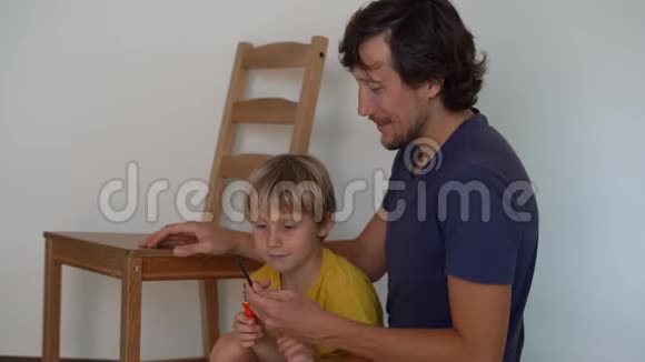 父亲和他的小儿子正在组装家具他们把厨房的椅子组装起来视频的预览图