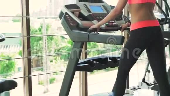 年轻健康的女人在健身房里跑步慢动作视频的预览图