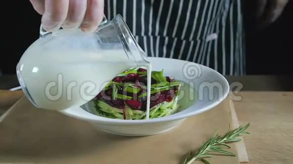 厨师手在木桌上添加牛奶至沙拉视频的预览图