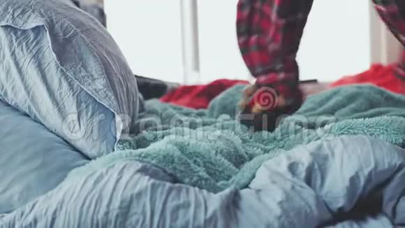 一个穿着睡衣的幸福女人在豪华公寓里的特大床上跳跃慢动作视频的预览图