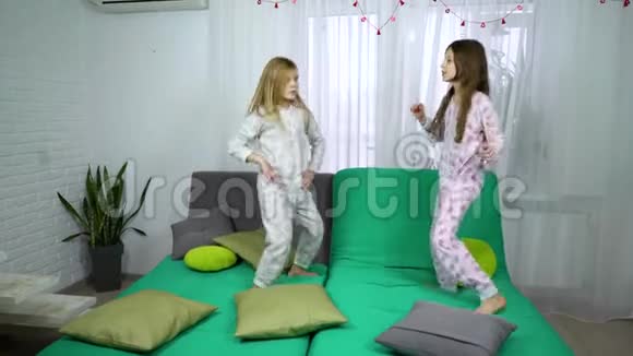 两个穿着睡衣的小女孩在沙发上跳舞视频的预览图