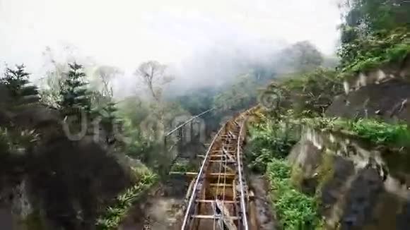 在山上穿过森林铁路的火车火车去车库多云天气视频的预览图