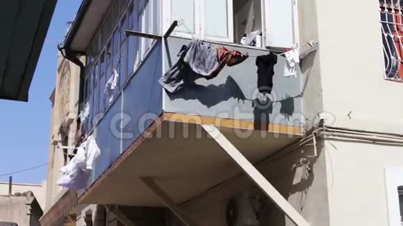 东西挂在阳台上发展在城市的阳光下一切都在绳索上干燥洗过的男人在绳子上干燥视频的预览图