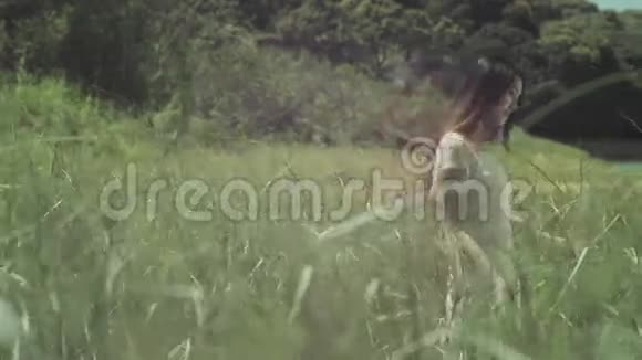 在芦苇丛中行走的年轻女子视频的预览图