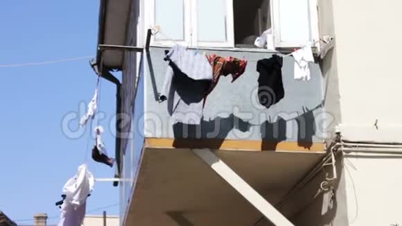 东西挂在阳台上发展在城市的阳光下一切都在绳索上干燥洗过的男人在绳子上干燥视频的预览图