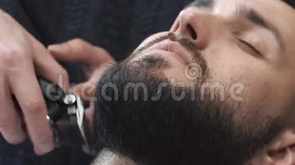 理发店理发师用剪子剪胡子特写视频4k理发师和电动修剪机一起工作视频的预览图
