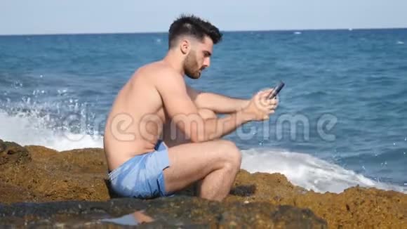 沙滩上的年轻人用电子书阅读视频的预览图