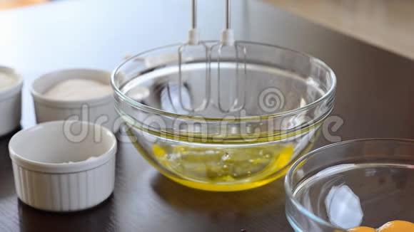 女人用搅拌器把蛋清搅拌成玻璃碗视频的预览图