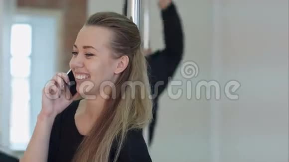 快乐的钢管舞者在上课时用手机打电话视频的预览图