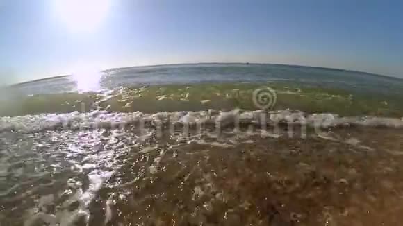 慢动作海浪与白色泡沫卷到沙滩视频的预览图