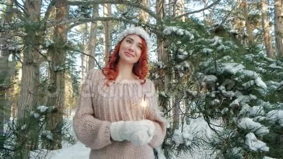 美丽的女孩在冬天的树林里冬天的大自然女孩拿着闪闪发光冬天的童话视频的预览图