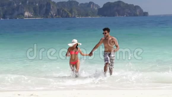 沙滩上的情侣牵手幸福的微笑海上度假的游客视频的预览图