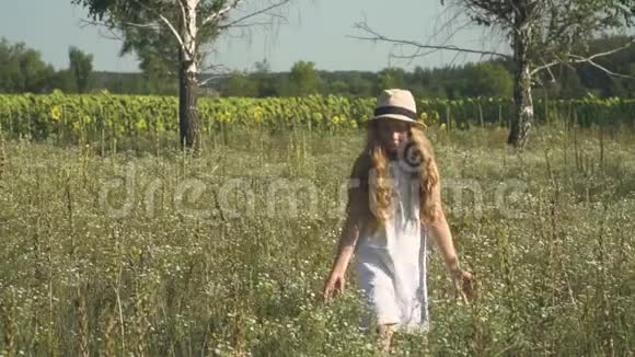 戴帽子的漂亮孩子在草地上散步视频的预览图