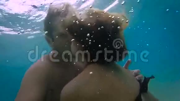甜蜜的一对情侣在海水下接吻慢动作视频的预览图