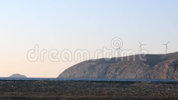 太阳下山时海洋海岸线上的风力发电机视频的预览图