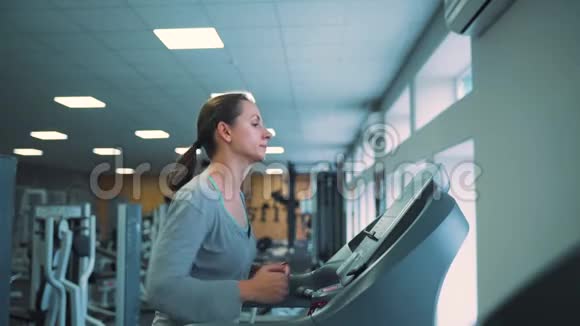 在健身房跑步机上跑步的女人慢动作视频的预览图