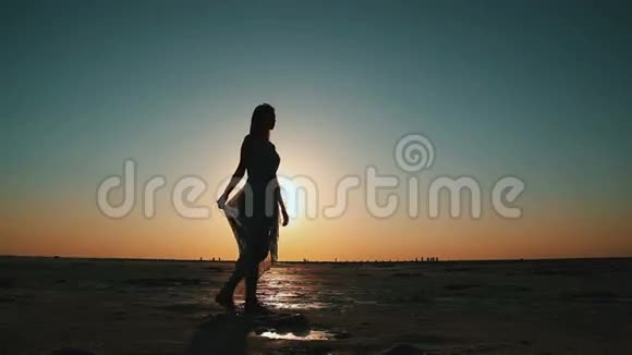 剪影幸福的女人在夕阳的背景下天空视频的预览图