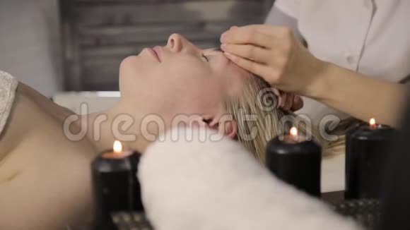 做面部按摩的美女在美容水疗中心用油进行手指按摩视频的预览图