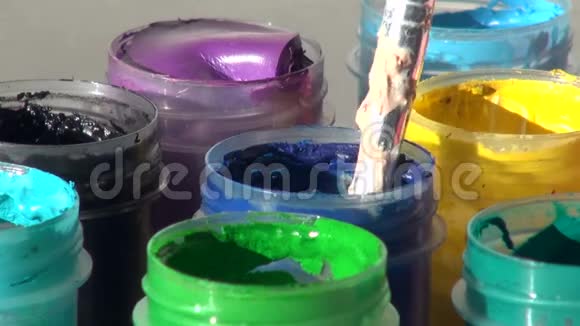刷子浸在一罐蓝色丙烯酸水粉颜料中家庭作业视频的预览图
