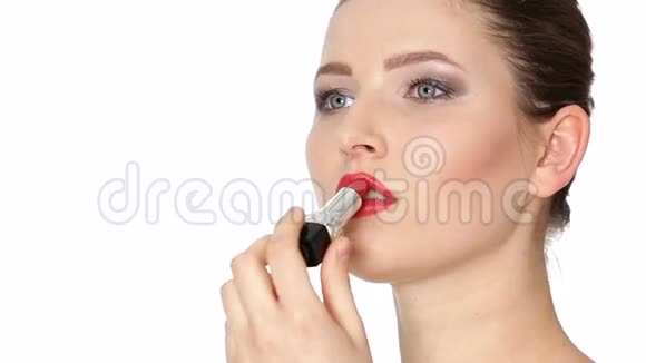 女人在白色背景上的嘴唇上涂红色口红视频的预览图