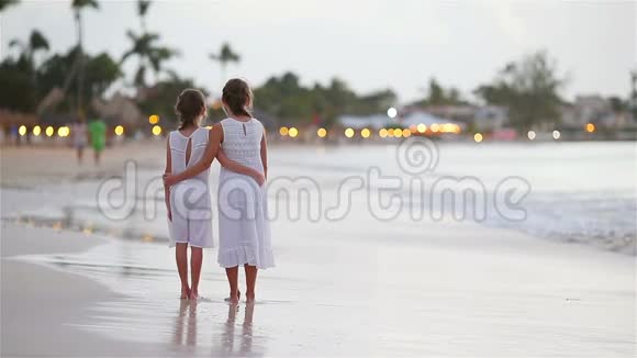 可爱的孩子们在海滩上散步美丽的五颜六色的日落视频的预览图