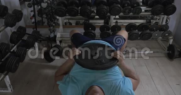 一个在健身房里躺在长椅上的成年人抬起头视频的预览图