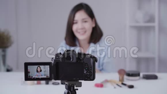 快乐微笑的亚洲女人或美女博主用画笔和相机录制视频并在家挥手视频的预览图
