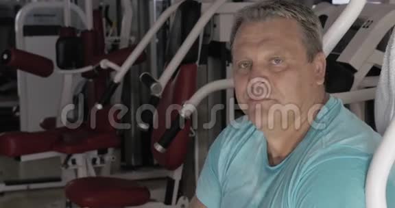 在健身房锻炼期间拇指向上并微笑的老人视频的预览图