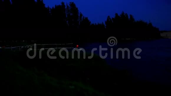 夜间黑天下黑暗湖水上滑板车视频的预览图