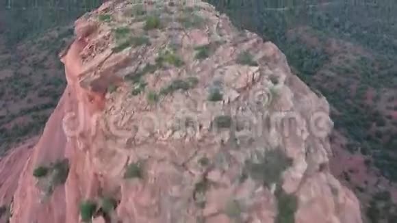 傍晚日落时在草原自然山岭景观的大粉红色石岩悬崖上鸟瞰4k视频的预览图