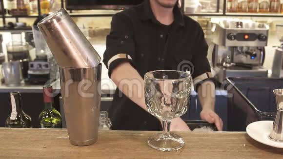 男手调酒师把冰块倒入鸡尾酒中视频的预览图