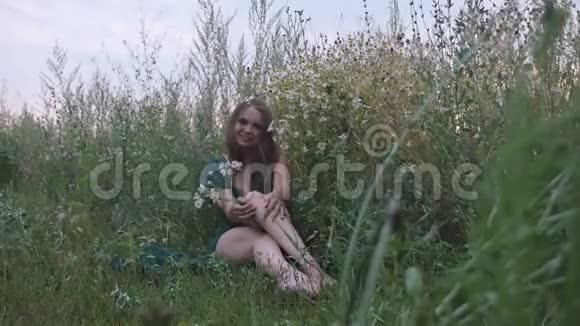 穿着鲜花坐在田野里的女孩视频的预览图