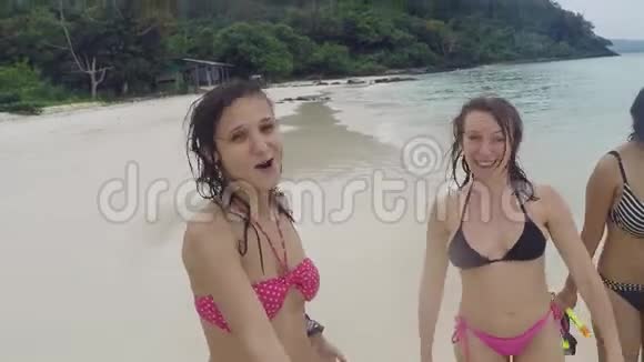 三个穿着比基尼的快乐女人在海滩上聚会手里拿着潜水面具视频的预览图
