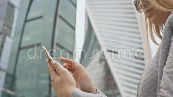 女孩在市中心高楼大厦的背景下打电话视频的预览图