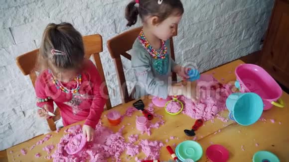 两个小女孩在桌子上玩动能沙视频的预览图