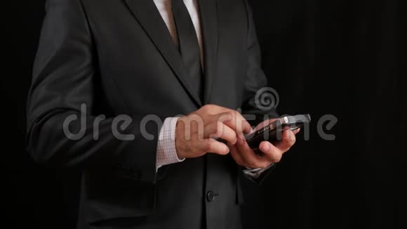 概念数字在线生活和社交网络一个穿黑色西装打领带的商人用他的智能手机视频的预览图