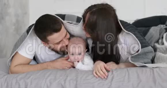 快乐的年轻微笑的家庭和宝宝玩视频的预览图
