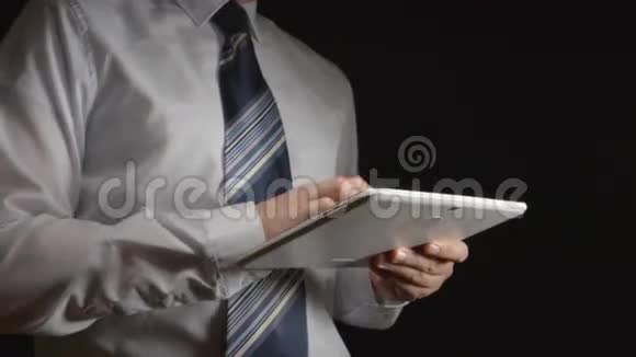 穿着白色衬衫和领带的男人手里拿着一台白色平板电脑半侧视图视频的预览图