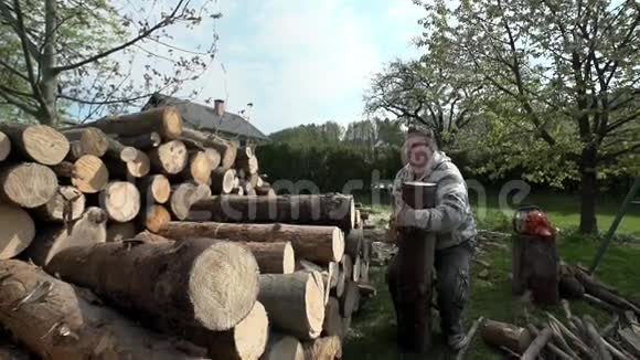 一个人在一堆被砍的木头上扔巨大的木头视频的预览图