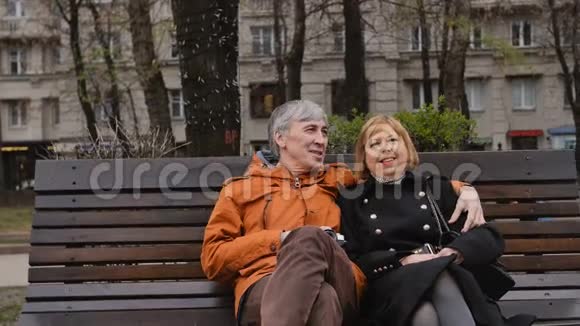 可爱的成熟夫妇在长凳上放松聊天视频的预览图