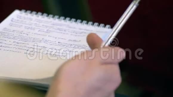 男用手拿笔和练习册旋转一支笔特写视频的预览图