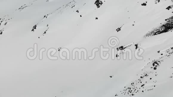 鸟瞰冬山景观埃尔布鲁斯南部度假胜地积雪覆盖的岩石斜坡视频的预览图