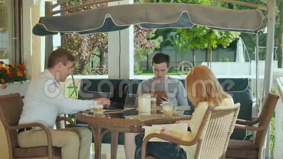 英俊的家庭坐在露台上喝咖啡视频的预览图