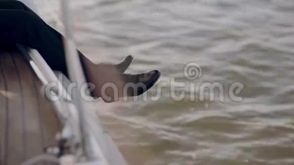 从游艇上往下看人腿的近景商人一个人在帆板上休息一下视频的预览图