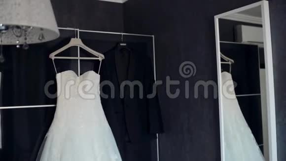 结婚纪念日衣服和西装挂在公寓里准备仪式视频的预览图