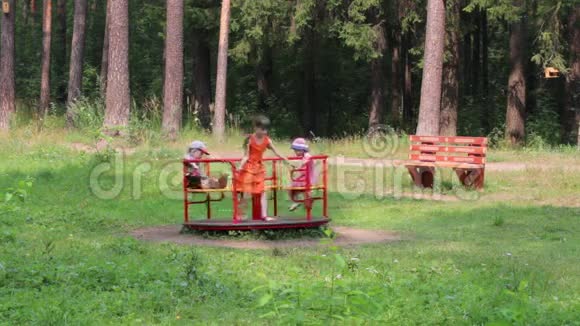 三个快乐的孩子在绿色公园玩环形交叉路口视频的预览图