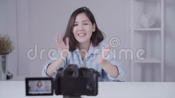快乐微笑的亚洲女人或美女博主用画笔和相机录制视频并在家挥手视频的预览图
