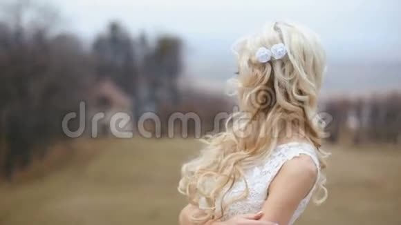 美丽时尚的金发新娘长发在模糊的城堡背景下摆姿势视频的预览图