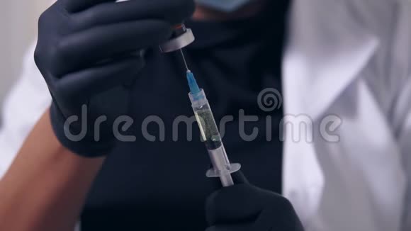 专业医生戴手套和口罩手里拿着医用注射器准备注射特写视图视频的预览图