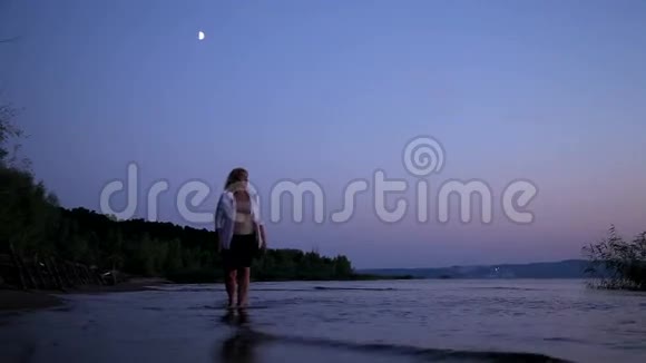 女孩在日落时在水上散步视频的预览图
